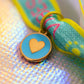 Close-up of the teal and gold heart medallion charm