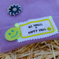 Close-up of smiley patches on the All Smiles & Happy Vibes lilac beanie