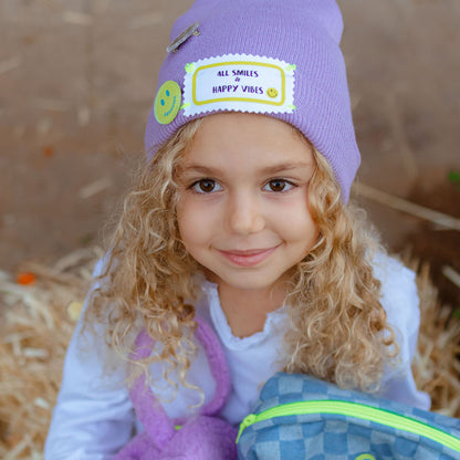 Child wearing the All Smiles & Happy Vibes beanie with smiley patches