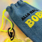 Denim drawstring pouch with Allo Maman Bobo text in yellow and black lettering