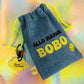 Full view of the denim Allo Maman Bobo first aid kit pouch with yellow drawstrings and smiley tag
