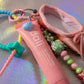 Detailed view of the Ballerina Key Charm featuring pink ballet shoe, beads, and lip balm charm