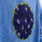 Close-up of navy smiley face bandana patch on denim blue bathrobe