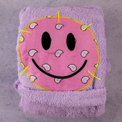 Folded lavender lilac bandana smiley bathrobe with pink smiley patch