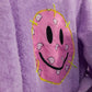 Close-up of pink smiley face patch on lavender lilac bathrobe
