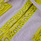 Close-up of yellow bandana trim detailing on cotton white smiley bathrobe