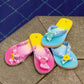 blue and pink bandana flip flops with charms displayed near pool