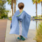 Child walking in denim blue bandana smiley poncho showing back panel