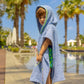 Side view of child wearing denim blue bandana smiley poncho at the pool