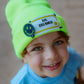 Child smiling while wearing the neon Big Dreamer beanie