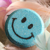 Close-up of blue smiley face bath bomb for fun self-care gifting