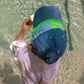 top view of boys cool denim cap with green smiley detail and blue bandana trim
