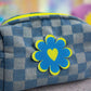 close-up of checkered denim pouch showing blue flower-heart detail