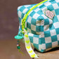 Side view of aqua blue checkered puffy pouch with quilted construction