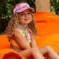 girl in swimwear wearing pink beaded visor