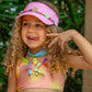 girl wearing pink beaded visor and smiling