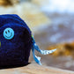 Side view of Curious Deep Sea Towel Puffy cosmetic bag with smiley button and ribbon pull