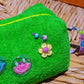 Close-up of Curious Lime towel cosmetic bag with flower charm and smiley patches