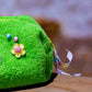Side view of Curious Lime towel cosmetic pouch with decorative flower charm