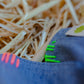 Close-up of green thread stitching on denim scrunchie