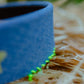 Close-up of denim wide headband showing neon green hand-stitch detail