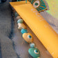Eye Key Charm with blue and yellow beaded strand next to yellow lip balm