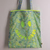 Floral Happy Vibes tote bag with neon smiley face design on the front