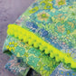 Detail of neon pom-pom trim on floral Happy Vibes tote bag