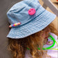 close up of girls denim bucket hat with multicoloured beads and pink smiley patch
