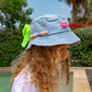 side view of girls denim bucket hat with neon bow and colourful beaded band