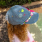 close front view of denim cap worn with pastel beads and smiley charms