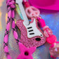 Macro shot of the Pink Glitter Electric Guitar Charm, highlighting the texture and the bright pink Pop Punk color scheme