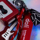 Detail showing the red Glitter Guitar Keychain, the red and white specked paracord, and the coordinating red lip balm prop
