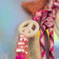 Aesthetic macro shot of glitter graffiti heart key charm with pink beads