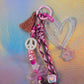 Detailed view of glitter key charm beads including star, heart, bow and pink accent beads
