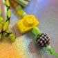 Artistic flat lay of peach graffiti heart key charm with neon green cord and retro beads