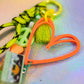 Peach graffiti heart key charm cassette bead and neon rope detail in artistic flat lay