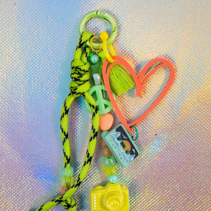 Peach graffiti heart key charm attached to green keyring with tassel and decorative beads