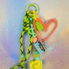 Peach graffiti heart key charm attached to green keyring with tassel and decorative beads