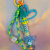 Close-up of sky blue graffiti heart key charm showing peace sign bead, star charm and tassel