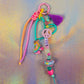 Full view of the chunky beaded keychain featuring a teal heart, neon pink and orange paracord, and a fun roller skate charm