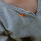 Hand-stitched neckline detail on light grey graffiti smiley long sleeve T-shirt