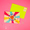 Colourful happy times greeting card with rainbow rays, smiley face and bright envelope