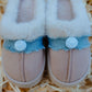 Close-up front view of kids fluffy smiley slip-on slippers with soft sole and smiley detail