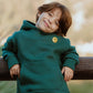Child wearing galaxy green fleece hoodie from Kindness is Cool jogger set with front smiley badge detail