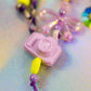 Macro shot of the lilac camera charm and a large yellow bead on the Chunky Beaded Keychain
