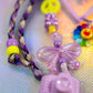 Beaded Keychain detail showing the shimmering lilac bow charm, small clear star beads, and purple paracord knotting