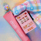 Flat lay of the Mini Slot Machine Key Charm and matching pastel plaid ribbon