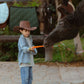 Boy feeding a horse while wearing Pocket Full of Dreams kids denim shirt outdoors