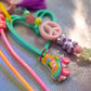 Macro shot of the Roller Skate Keychain Charm, which features bright neon colors like teal, pink, and yellow